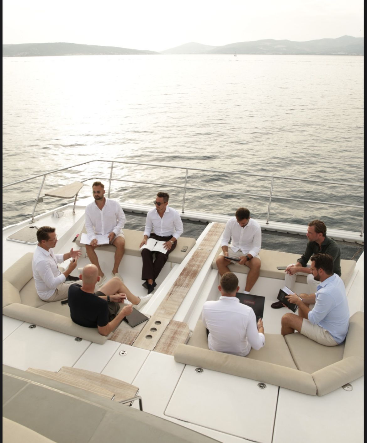 Die Teilnehmer sitzen im Kreis auf dem Deck des Katamarans