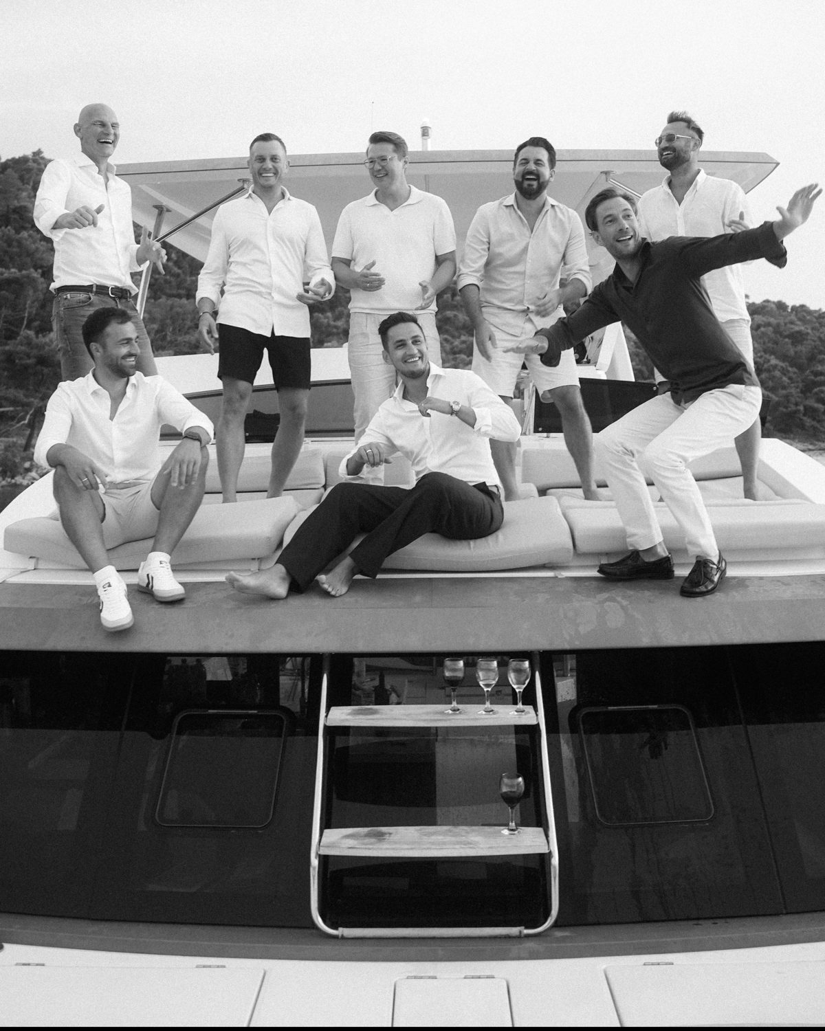 Die Teilnehmer der CEO Yacht Mastermind lachend auf dem Heck des Katamarans