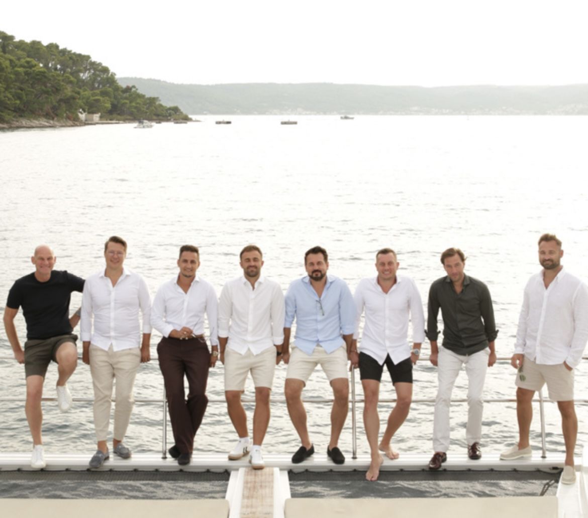 Die Teilnehmer der Yacht Mastermind auf einem Steg am Meer